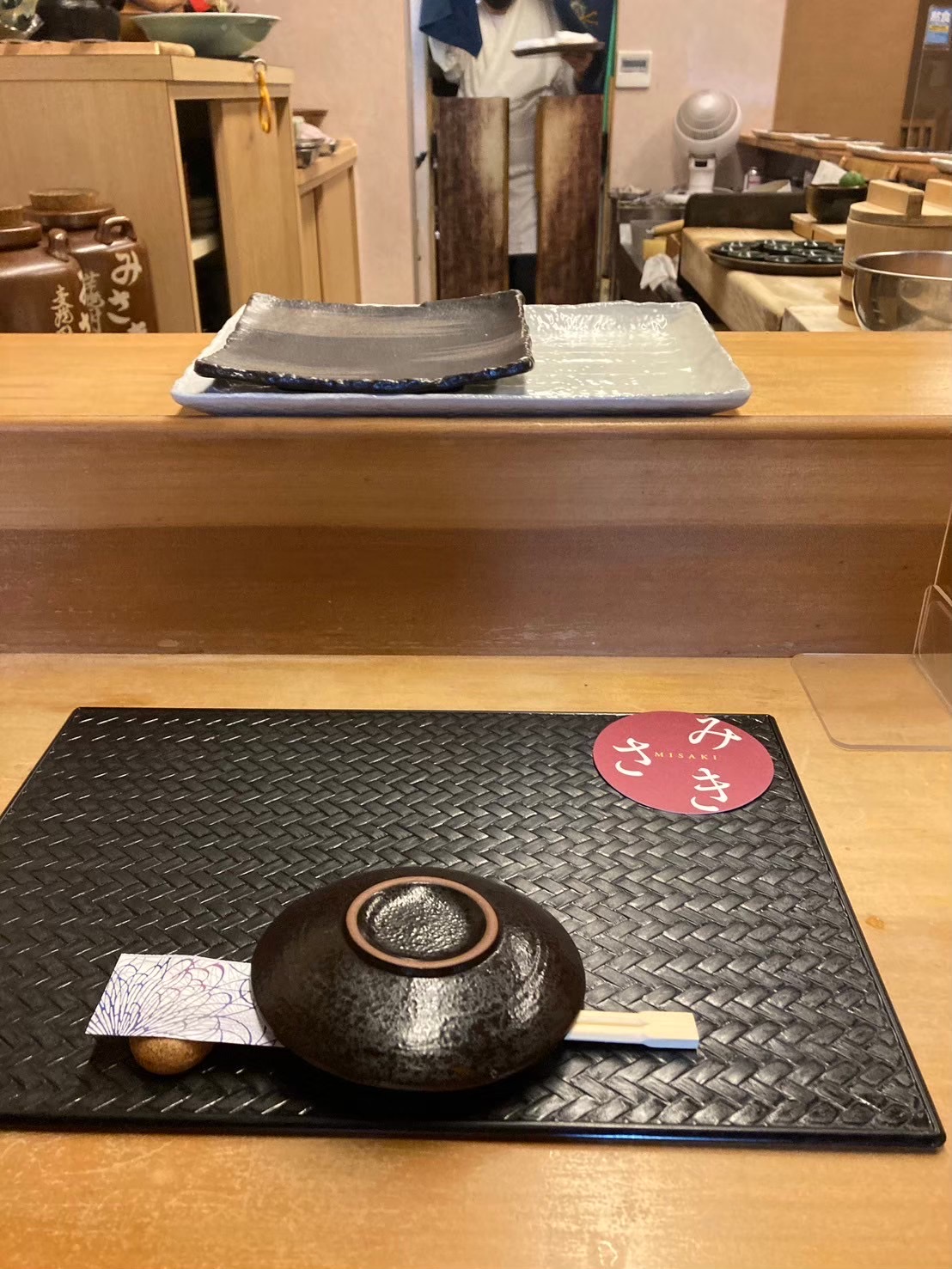 みさきのカウンター席と食事の器、店名入りコースター