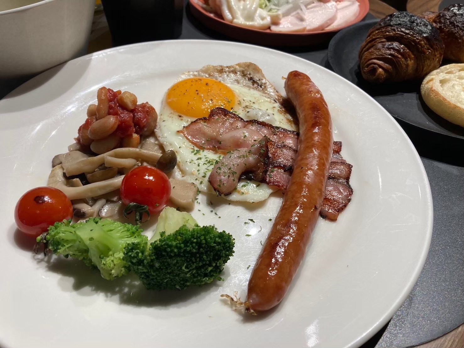 目玉焼き、ソーセージ、ベーコン、野菜を盛った朝食のプレート
